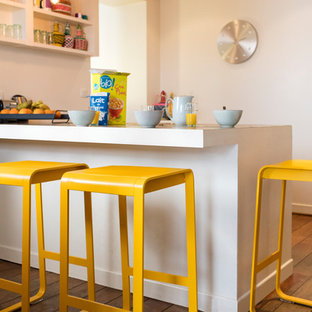 Kleine Moderne Küche mit braunem Holzboden, Halbinsel, braunem Boden und weißer Arbeitsplatte in Köln