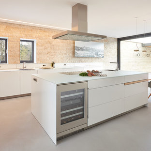 This is an example of a large contemporary l-shaped separate kitchen in Stuttgart with an integrated sink, flat-panel cabinets, white cabinets, beige splashback, stone slab splashback, stainless steel appliances, vinyl floors, with island, grey floor and white benchtop.