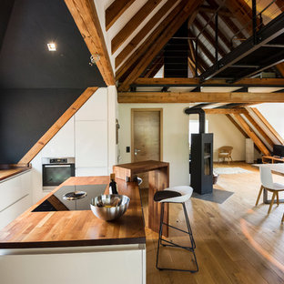 Offene, Mittelgroße Moderne Küche mit Einbauwaschbecken, flächenbündigen Schrankfronten, weißen Schränken, Arbeitsplatte aus Holz, Elektrogeräten mit Frontblende, braunem Holzboden und Kücheninsel in München