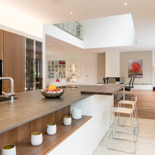 Offene, Zweizeilige, Große Moderne Küche mit Unterbauwaschbecken, flächenbündigen Schrankfronten, hellbraunen Holzschränken, Kücheninsel, beigem Boden und grauer Arbeitsplatte in Düsseldorf