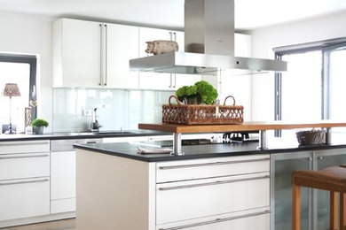 Offene Landhausstil Küche in U-Form mit Küchenrückwand in Weiß, Glasrückwand, Travertin, weißen Schränken, schwarzen Elektrogeräten und Kücheninsel in Stuttgart