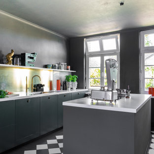 Industrial Küche mit Doppelwaschbecken, flächenbündigen Schrankfronten, grünen Schränken, Marmor-Arbeitsplatte, Küchenrückwand in Metallic, Keramikboden, Kücheninsel, weißer Arbeitsplatte und buntem Boden in Dortmund