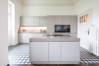 Große, Offene Moderne Küche mit integriertem Waschbecken, Quarzwerkstein-Arbeitsplatte, schwarzen Elektrogeräten und Kücheninsel in Köln