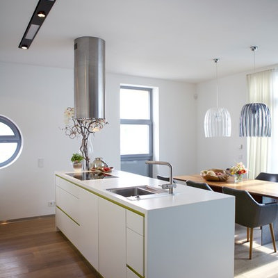 Inspiration for a mid-sized contemporary medium tone wood floor and brown floor eat-in kitchen remodel in Cologne with a drop-in sink, flat-panel cabinets, white cabinets, an island and white countertops