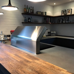 This is an example of a large industrial u-shaped eat-in kitchen in Other with an integrated sink, flat-panel cabinets, grey cabinets, quartz benchtops, white splashback, brick splashback, stainless steel appliances, dark hardwood floors, a peninsula and yellow benchtop.