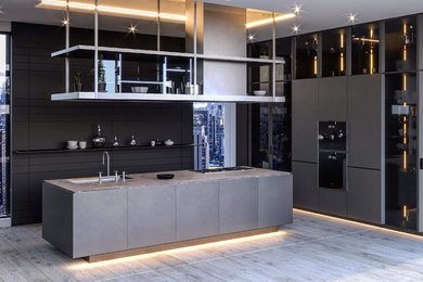 Moderne Küche in U-Form mit flächenbündigen Schrankfronten, grauen Schränken, schwarzen Elektrogeräten, Kücheninsel, grauem Boden und grauer Arbeitsplatte in Hannover