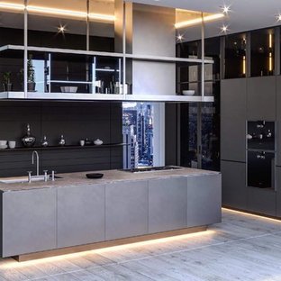 Moderne Küche in U-Form mit flächenbündigen Schrankfronten, grauen Schränken, schwarzen Elektrogeräten, Kücheninsel, grauem Boden und grauer Arbeitsplatte in Hannover