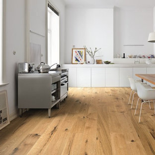 Moderne Küche ohne Insel in L-Form mit flächenbündigen Schrankfronten, weißen Schränken, braunem Holzboden, braunem Boden und weißer Arbeitsplatte