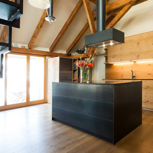 Offene, Zweizeilige, Mittelgroße Asiatische Küche mit flächenbündigen Schrankfronten, Küchenrückwand in Braun, Rückwand aus Holz, braunem Holzboden, Kücheninsel, braunem Boden, schwarzer Arbeitsplatte und schwarzen Schränken in München