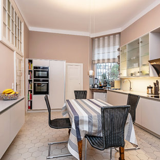 Geschlossene, Zweizeilige, Mittelgroße Moderne Küche ohne Insel mit integriertem Waschbecken, flächenbündigen Schrankfronten, weißen Schränken, Mineralwerkstoff-Arbeitsplatte, Küchenrückwand in Beige, Glasrückwand, schwarzen Elektrogeräten, Zementfliesen, beigem Boden und beiger Arbeitsplatte in Berlin