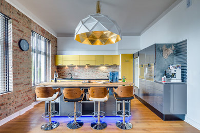 Moderne Küche in L-Form mit Unterbauwaschbecken, flächenbündigen Schrankfronten, gelben Schränken, Küchengeräten aus Edelstahl, hellem Holzboden und Kücheninsel in Hamburg