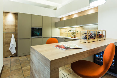 Moderne Küche in U-Form mit flächenbündigen Schrankfronten, braunen Schränken, Arbeitsplatte aus Holz, Küchengeräten aus Edelstahl und Halbinsel in Sonstige