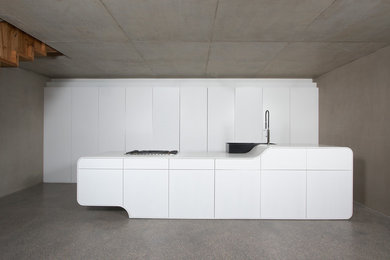 Offene, Mittelgroße Moderne Küche mit flächenbündigen Schrankfronten, Mineralwerkstoff-Arbeitsplatte, Betonboden und Kücheninsel in Sonstige