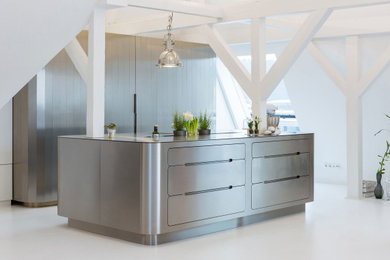 Design ideas for a large modern galley kitchen/diner with a built-in sink, flat-panel cabinets, stainless steel cabinets, stainless steel worktops, stainless steel appliances, an island, concrete flooring, white floors and exposed beams.