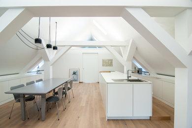 Moderne Küche mit weißen Schränken, Arbeitsplatte aus Holz, Küchengeräten aus Edelstahl und weißer Arbeitsplatte in Sonstige