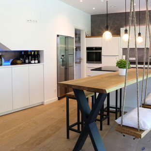 Offene, Große Moderne Küche in L-Form mit flächenbündigen Schrankfronten, weißen Schränken, Arbeitsplatte aus Holz, Küchenrückwand in Grau, Küchengeräten aus Edelstahl, braunem Holzboden, Kücheninsel, braunem Boden und beiger Arbeitsplatte in Bremen