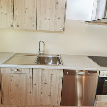Küchenrenovierung: weiße Holz-Optik mit heller Schichtstoff-Arbeitsplatte