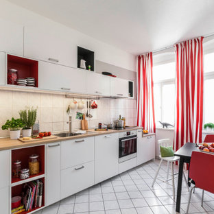 Einzeilige Moderne Küche mit weißen Schränken und Arbeitsplatte aus Holz in Hamburg