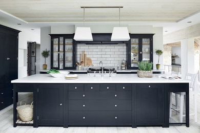 Foto di una grande cucina classica con ante di vetro, paraspruzzi bianco, paraspruzzi con piastrelle diamantate e pavimento in legno verniciato