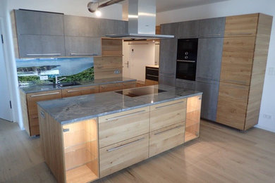Moderne Küche mit flächenbündigen Schrankfronten und Kücheninsel in Sonstige