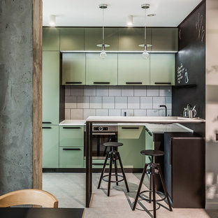 Kleine, Zweizeilige Moderne Wohnküche mit grünen Schränken, Betonboden, flächenbündigen Schrankfronten, Küchenrückwand in Weiß, Küchengeräten aus Edelstahl, Halbinsel, grauem Boden und weißer Arbeitsplatte in Berlin