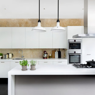 Mittelgroße, Zweizeilige Moderne Küche mit dunklem Holzboden, flächenbündigen Schrankfronten, weißen Schränken, Küchenrückwand in Beige, Küchengeräten aus Edelstahl, Kücheninsel, weißer Arbeitsplatte, Doppelwaschbecken und schwarzem Boden in Hamburg