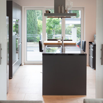 Modern-minimalistische offene Wohnküche in Anthrazit