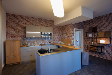 Offene, Große Moderne Küche in U-Form mit Doppelwaschbecken, Glasrückwand, schwarzen Elektrogeräten, Porzellan-Bodenfliesen, Kücheninsel und grauem Boden in Sonstige