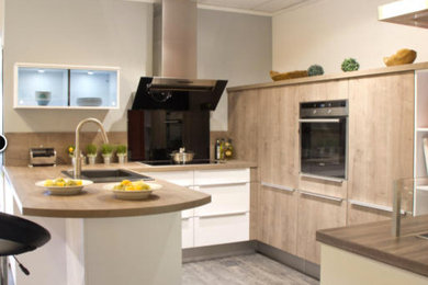 Photo of a medium sized contemporary u-shaped open plan kitchen in Other with a built-in sink, raised-panel cabinets, light wood cabinets, wood worktops, multi-coloured splashback, stainless steel appliances and lino flooring.