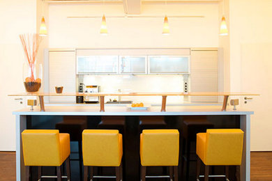 Offene, Einzeilige, Mittelgroße Moderne Küche mit flächenbündigen Schrankfronten, beigen Schränken, dunklem Holzboden, Kücheninsel und braunem Boden in München