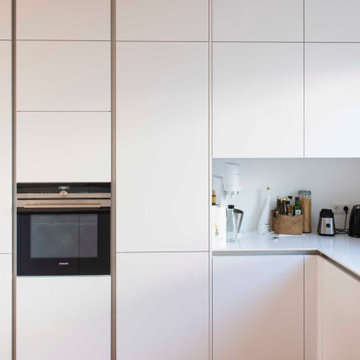 Moderne weiße Küche in U-Form, grifflos