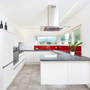 Offene, Mittelgroße Moderne Küche in U-Form mit Unterbauwaschbecken, flächenbündigen Schrankfronten, weißen Schränken, Küchenrückwand in Rot, Halbinsel, beigem Boden, grauer Arbeitsplatte, Arbeitsplatte aus Holz, Glasrückwand, Küchengeräten aus Edelstahl und Keramikboden in Stuttgart