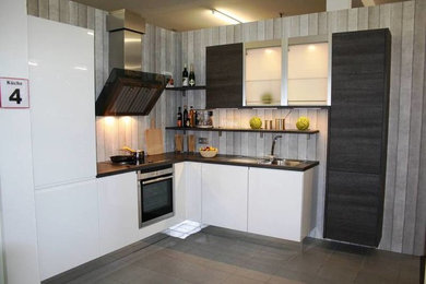 Offene Moderne Küche in L-Form mit weißen Schränken, Laminat-Arbeitsplatte und Küchengeräten aus Edelstahl in Stuttgart