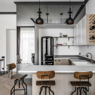 Skandinavische Küche in U-Form mit weißen Schränken, Küchenrückwand in Weiß, braunem Holzboden, braunem Boden, weißer Arbeitsplatte, Landhausspüle, Schrankfronten mit vertiefter Füllung, Glasrückwand, schwarzen Elektrogeräten und Halbinsel in Stuttgart