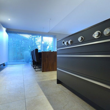 Offene Wohnküche in schwarz mit Holzelementen