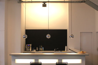 Offene, Kleine Moderne Küche in U-Form mit Einbauwaschbecken, dunklem Holzboden und Halbinsel in Berlin