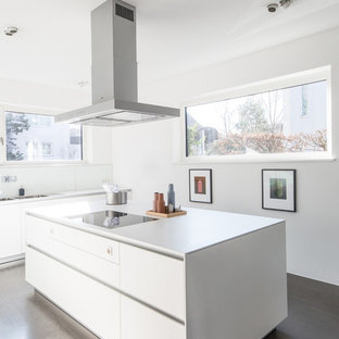 Einzeilige, Mittelgroße Moderne Küche mit Doppelwaschbecken, flächenbündigen Schrankfronten, weißen Schränken, Küchenrückwand in Weiß, Glasrückwand, Kücheninsel, beigem Boden und weißer Arbeitsplatte in Köln
