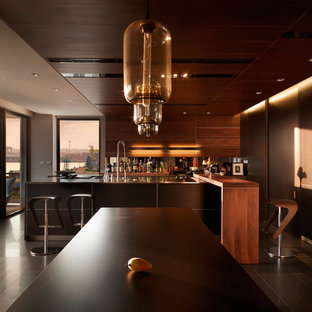 Modelo de cocina comedor contemporánea, grande, con armarios con paneles lisos, puertas de armario de madera en tonos medios, electrodomésticos de acero inoxidable, suelo de madera pintada y una isla