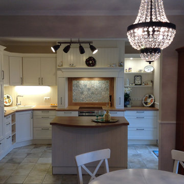 schicke Landhausküche mit Arbeitsinsel und stylischem Fliesenspiegel
