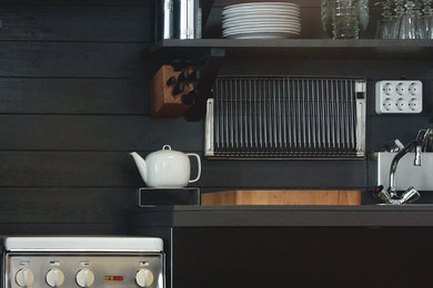 Einzeilige, Kleine Moderne Küche mit schwarzen Schränken, Küchenrückwand in Grau und Rückwand aus Holz in Leipzig