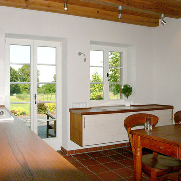 separater Küchenblock vor dem Fenster und Zugang zur Terrasse