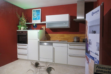 Modelo de cocina lineal actual pequeña con fregadero de un seno, puertas de armario blancas, encimera de laminado y electrodomésticos de acero inoxidable