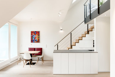 Offene, Zweizeilige, Mittelgroße Moderne Küche mit flächenbündigen Schrankfronten, grauen Schränken, hellem Holzboden, Kücheninsel und braunem Boden in Hamburg