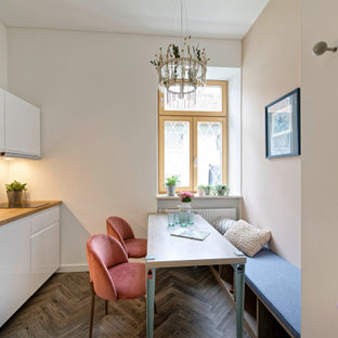 Einzeilige Moderne Wohnküche ohne Insel mit Einbauwaschbecken, flächenbündigen Schrankfronten, weißen Schränken, Arbeitsplatte aus Holz, dunklem Holzboden, braunem Boden und brauner Arbeitsplatte in München