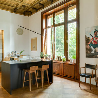 Große Moderne Küche mit flächenbündigen Schrankfronten, weißen Schränken, braunem Holzboden, Kücheninsel, braunem Boden und weißer Arbeitsplatte in Düsseldorf