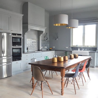 Immagine di un'ampia cucina country con lavello stile country, paraspruzzi blu, elettrodomestici neri, parquet chiaro, ante in stile shaker, ante blu e nessuna isola