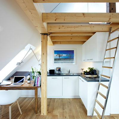 Small trendy l-shaped medium tone wood floor open concept kitchen photo in Munich with flat-panel cabinets, white cabinets, no island, a drop-in sink and paneled appliances