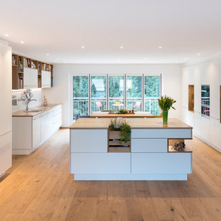 Idee per una grande cucina scandinava con lavello a doppia vasca, ante lisce, ante bianche, top in legno, paraspruzzi bianco, paraspruzzi con lastra di vetro, elettrodomestici in acciaio inossidabile, pavimento in legno massello medio, 2 o più isole, top marrone e pavimento turchese