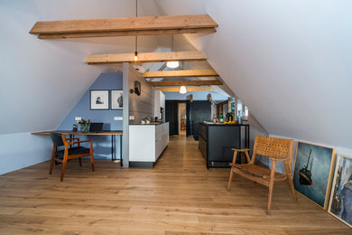 Aménagement d'une petite cuisine américaine parallèle scandinave avec un placard à porte plane, une crédence grise, un sol en bois brun, aucun îlot et un sol marron.