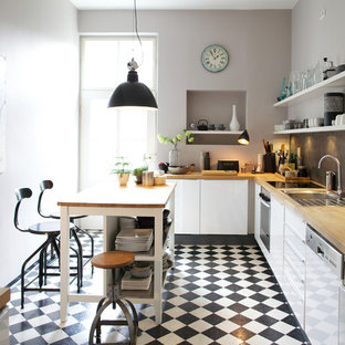 Design ideas for a large industrial l-shaped open plan kitchen in Munich with flat-panel cabinets, white cabinets, wood benchtops, grey splashback, slate splashback, coloured appliances, linoleum floors, with island and multi-coloured floor.